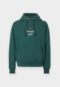 Felpa verde con cappuccio regolabile, tasca anteriore e logo "tommy girl" evidenziato da una stella. La trama del tessuto appare morbida e informale.