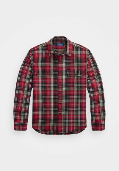 Camisa de cuadros roja, negra y crema con mangas largas, frente abotonado, dos bolsillos en el pecho y un dobladillo curvado. Tela de algodón con una textura suave.