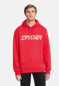 Haut à capuche rouge en mélange de coton avec une poche avant. Présente un logo "SPYDER" rayé blanc sur la poitrine. Capuche avec cordon de serrage et poignets côtelés.