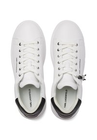 Valged nahast tossud sileda viimistlusega, millel on paelad, must kontsa aksent ja brändimine keeletel ja külgedel.