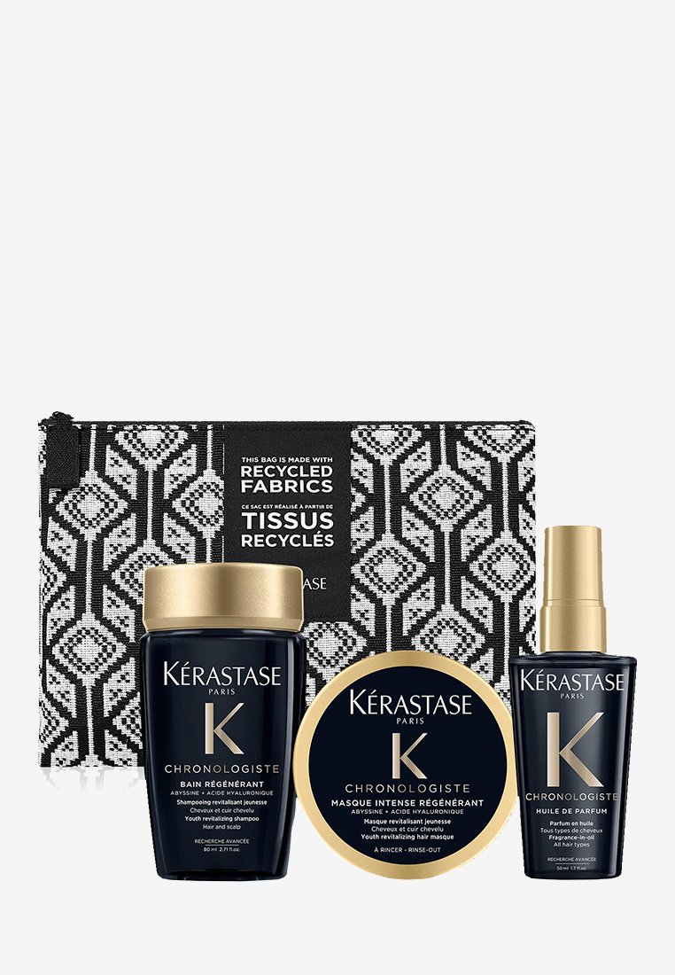 Shampoing Kérastase Chronologiste noir et or, masque capillaire et huile pour cheveux avec une pochette en tissu recyclé noir et blanc en arrière-plan.