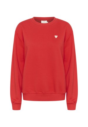 Sweatshirt rouge en tissu doux, avec un col rond, des manches longues et un petit logo en forme de cœur blanc sur la poitrine.