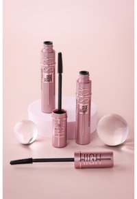 Due tubetti di mascara rosa con wand neri, uno dei quali è parzialmente aperto. Una sfera acrilica rotonda e una piattaforma rosa rotonda sono compresi nella composizione.