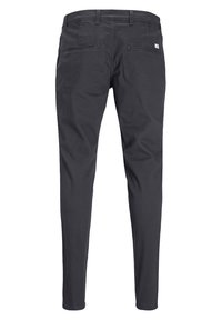 Ciemnoszare, slim-fit spodnie wykonane z miękkiego materiału. Posiadają dwie tylne kieszenie oraz minimalistyczną metkę z logo blisko pasa z tyłu.