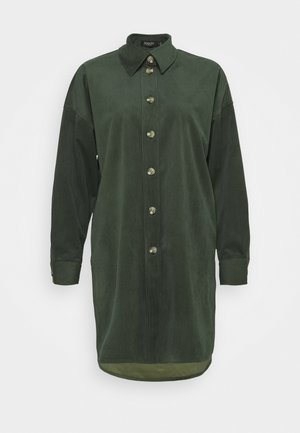 Green corduroy shirt dress with a collar, seven front buttons, and long sleeves. Features a straight cut and rounded hemline.