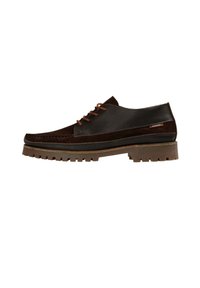 Zapato de cuero marrón y ante con puntera redondeada, diseño de cordones y suela de goma robusta con un gran relieve y una entresuela en tono beige.
