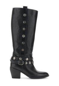 Bota de cuero negra a media pantorrilla con tacón cuadrado, tachuelas decorativas plateadas y una correa con hebilla alrededor del tobillo.