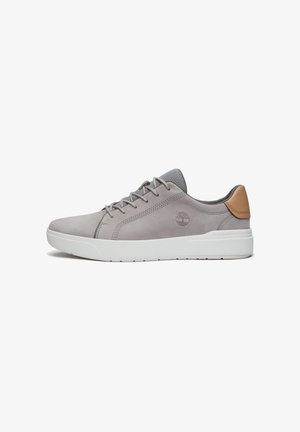 Sneaker en suède gris avec des accents en mesh, semelle en caoutchouc blanc et languette en cuir marron. Dispose d'un design à lacets et d'un détail de logo embossé.