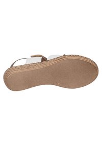 Sandalia blanca con plataforma de yute trenzado y suela de goma texturizada. La parte inferior es plana con un patrón de puntos para mayor tracción.