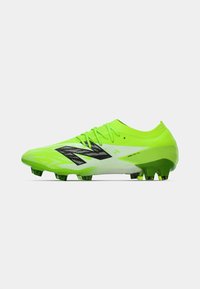 Crampon de football vert néon au design élégant, avec des accents noirs et une surface texturée. Il possède des crampons moulés pour une meilleure traction sur l'herbe.