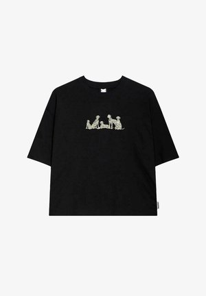 Camiseta negra de gran tamaño hecha de algodón, con un gráfico de color claro que muestra cinco perros en varias posiciones centrado en el pecho.