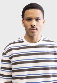 Striped short-sleeve sweater with horizontal lines in brown, dark blue, and light blue on a white background. Ribbed texture and crew neck.