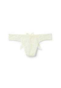 Koronkowe stringi w kremowym kolorze z kwiatowym wzorem, z kokardką na plecach i płaskim pasem. Miękkie, teksturowane materiały o delikatnym wyglądzie.
