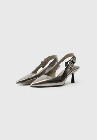 Metallic sølv slingback hæle med spidse tæer, en lav kitten hæl og justerbar ankelrem. Glat tekstur med et elegant design.