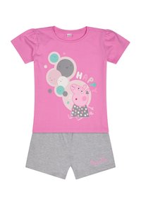 Un T-shirt rose à manches courtes présente un design graphique avec un cochon cartoon, entouré de cercles colorés, associé à un short gris.