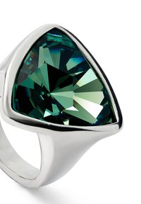 Bague en argent ornée d'une grande pierre verte triangulaire. La pierre présente de multiples facettes qui reflètent la lumière, avec un anneau en argent lisse et poli.