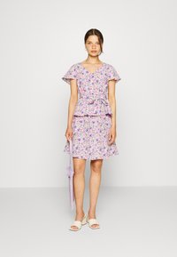 Vestido floral com decote em V, mangas curtas e franzidas, cintura peplum e saia fluida em lavanda com detalhes em rosa e verde.