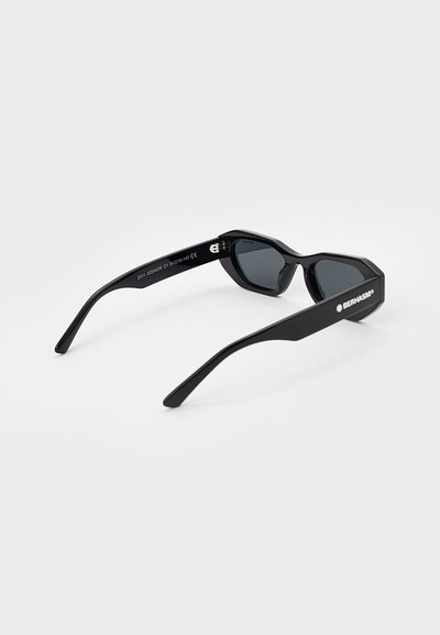 Black sunglasses with angular shape, dark lenses, and glossy finish. Features straight arms with logo on the side.