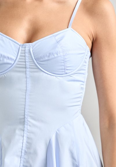 Lichtblauwe mouwloze jurk met een gestructureerde corsage en zachte stof. Bevat een geplooide textuur, zijnaad en prinsessen naden voor de juiste vorm.