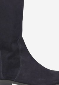 Botte en daim haute, bleu marine, au toucher lisse, au design ajusté, avec des coutures discrètes sur les côtés, et dotée d'une semelle plate.