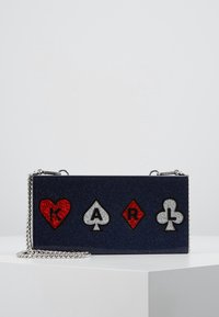Navy blue glitter handbag with silver chain strap, featuring decorative playing card symbols: red heart, black spade, red diamond, and black club.