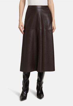 Bruine leren midi-rok met een gladde textuur, een aansluitende taille en naaddetails; gecombineerd met strakke zwarte hoge hakken.