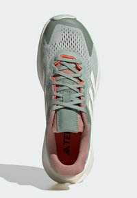 Scarpa da ginnastica verde con tomaia in rete traspirante, dettagli di corallo, lacci grigi, interno imbottito rosa e suola in gomma bianca. Design con tre strisce bianche.