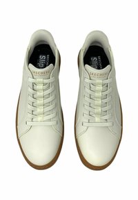 Zapatillas blancas con un upper sintético liso. Presenta cordones planos y una suela de goma. Logo "Skechers" grabado en la lengüeta.