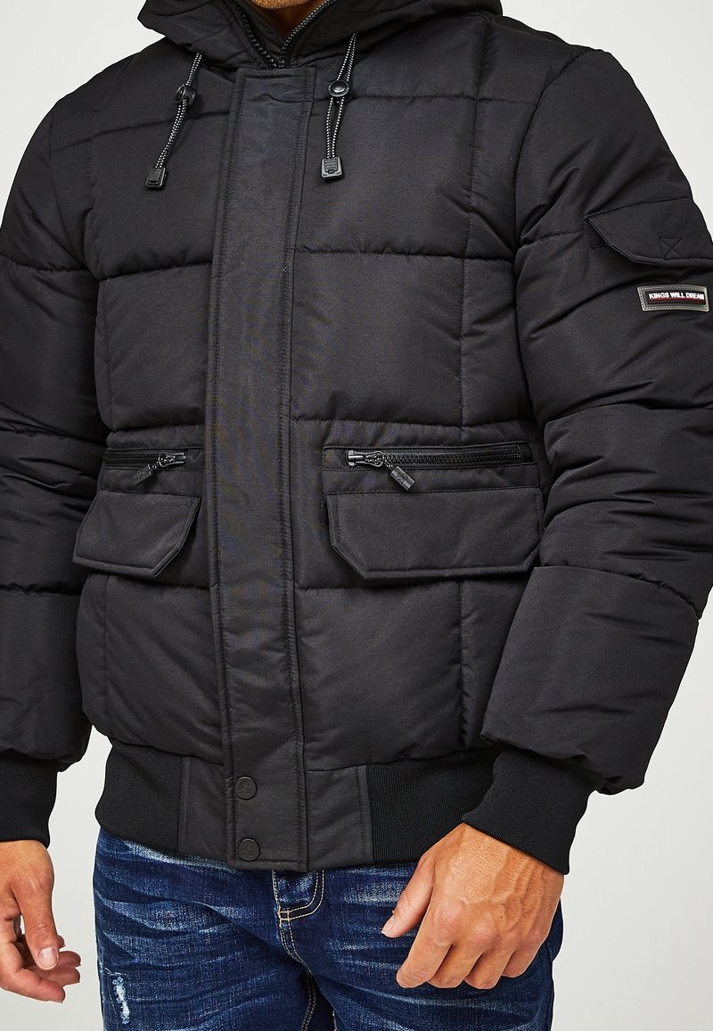 Černá bunda s kapucí; má prošívaný design, dvě přední kapsy na zip, žebrované manžety a nášivku s logem na rukávu.