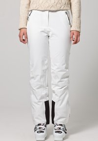 Witte skibroek met zwarte accenten, voorzien van ritsen bij de zakken en een rechte pasvorm. Gemaakt van een glad, waterdicht materiaal.