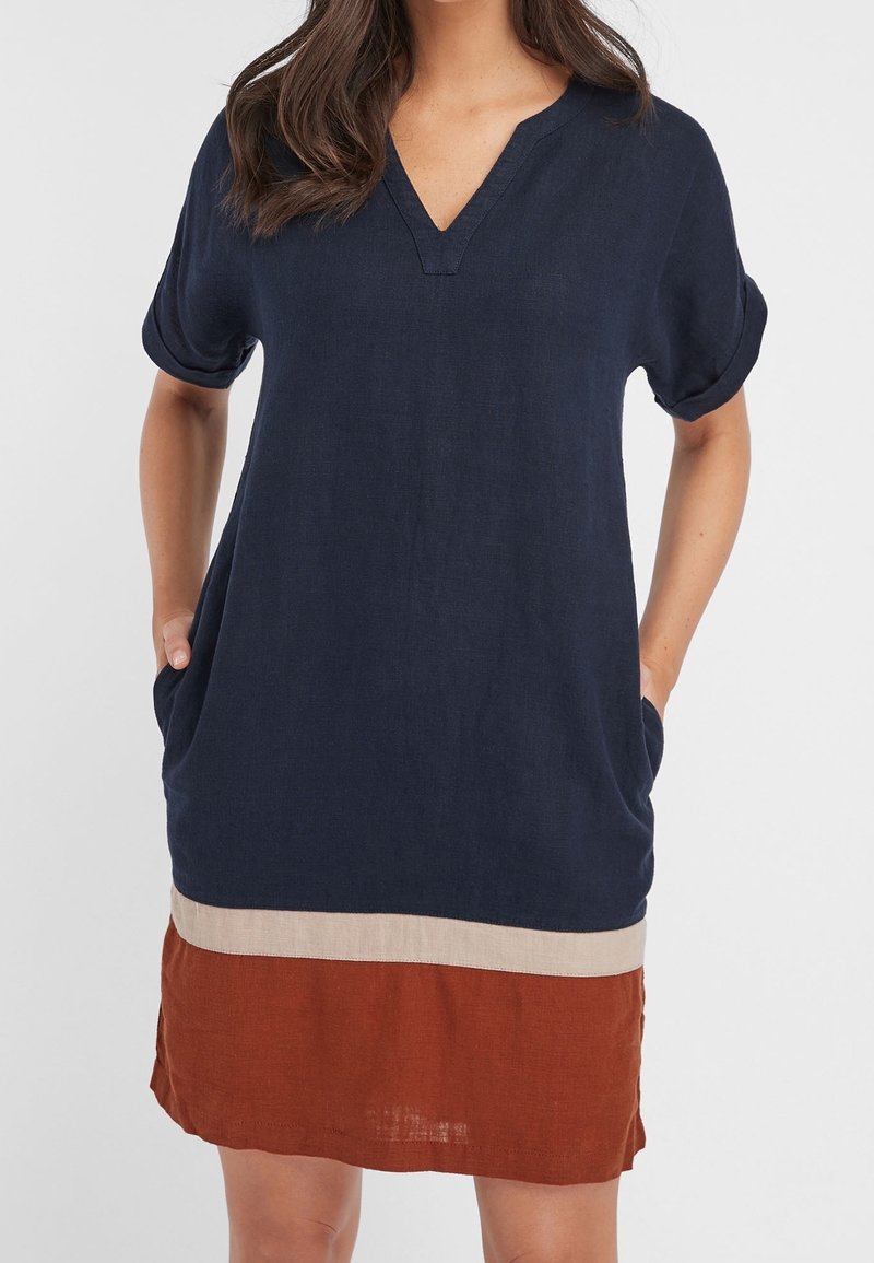 Robe en lin bleu marine avec un col en V, des manches courtes retroussées, des poches latérales et un ourlet à couches présentant un bloc de couleurs beige et rouille.