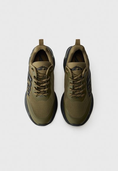 Olive green athletic shoes with a textured mesh upper, black rubber sole, and round laces. Features a pull tab on the heel and logo accents.