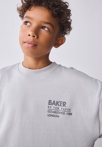Grijze sweatshirt met geribde ronde hals. Voorzien van een gedrukt logo "BAKER by TED BAKER Established 1988 LONDON" op de borst.