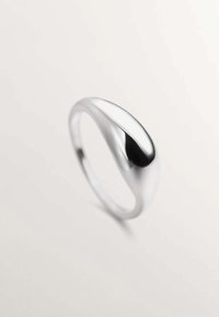Anillo de plata pulida con un diseño suave y curvado en forma de lágrima. La superficie es reflectante, mostrando una textura elegante.