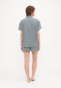 Svart og hvit rutete skjorte med korte ermer og matchende shorts, med krage og en avslappet passform. Glatt stoff, uformell design.