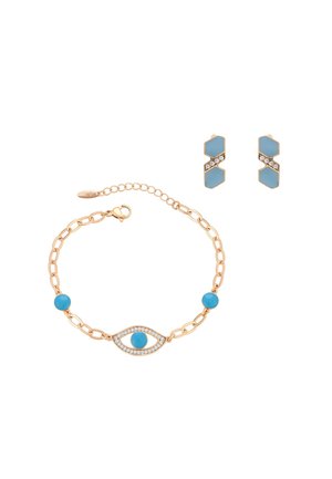 Aranylánc karkötő kék gyöngyökkel és strasszos szemmotívummal, arany és kék geometrikus fülbevalóval párosítva.