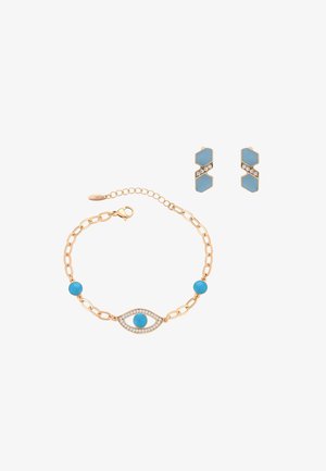 Aranylánc karkötő kék gyöngyökkel és strasszos szemmotívummal, arany és kék geometrikus fülbevalóval párosítva.
