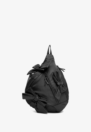 Schwarzer, tropfenförmiger Rucksack mit drei großen Stoffschleifen und mehreren Reißverschlussfächern.