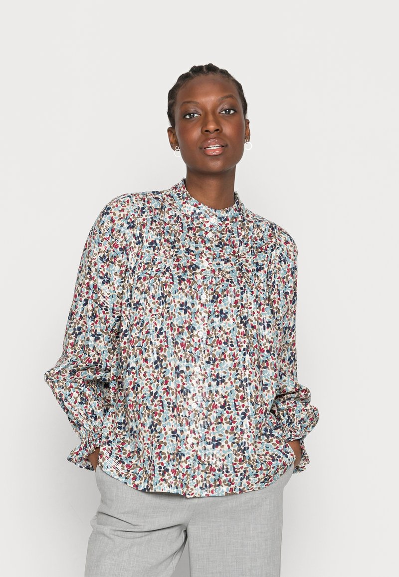 Blusa com padrão floral em tecido leve, apresentando um colarinho alto, mangas com punho elástico e um corte descontraído em tons multicoloridos.