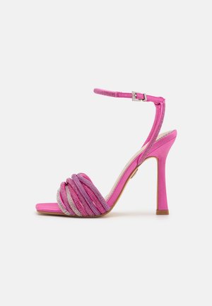 Rosa High-Heel-Sandalette mit gedrehten Stoffriemen und silbernen Akzenten, ausgestattet mit einem Knöchelriemen und einem glatten, spitzen Zehenbereich.