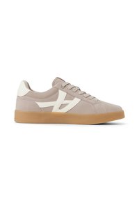 Sneaker in suede beige con accenti bianchi, punta rotonda, suola piatta in gomma e lacci tonali. Presenta un design distintivo con logo ritagliato.