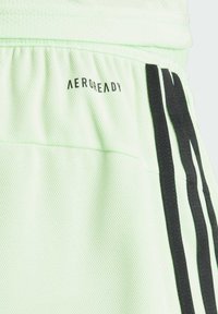 Shorts sportivi verde chiaro realizzati in tessuto a rete traspirante, con strisce verticali nere e logo "AEROREADY" sulla vita.