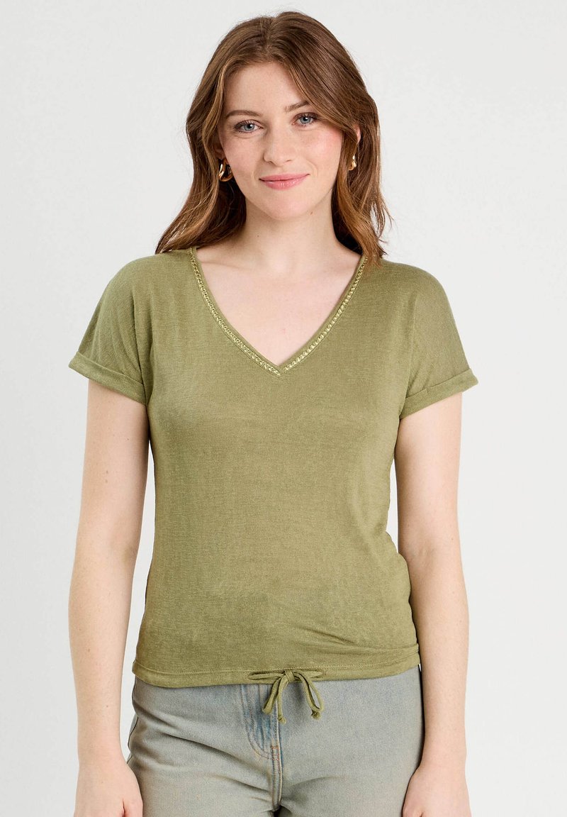 T-shirt vert olive à col en V avec des manches courtes retroussées, cordon de serrage à l'ourlet et couture décorative le long du col.
