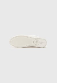 Semelle de sneaker blanche avec motif texturé et logo circulaire. Matériau en caoutchouc lisse, bout arrondi et design plat.