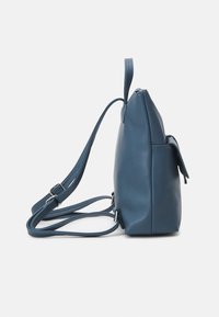 Sac à dos en cuir bleu avec une forme structurée, une sangle réglable, une fermeture éclair latérale et une poche extérieure pour plus de fonctionnalité.