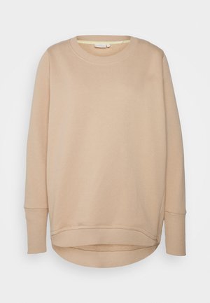 Sweat-shirt beige à manches longues avec col rond, poignets et bas côtelés, légèrement plus long à l’arrière.