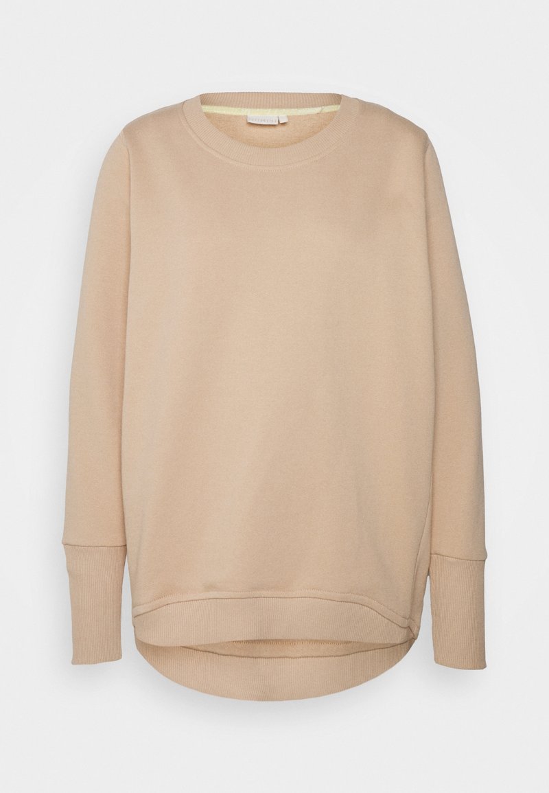 Sweat-shirt beige à manches longues avec col rond, poignets et bas côtelés, légèrement plus long à l’arrière.