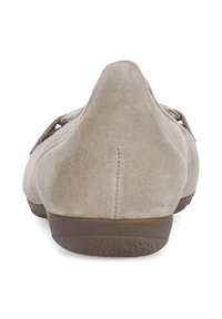 Beige suede schoenen met een lage hak, ronde achterkant en zichtbare stikdetails. De geprofileerde bruine zool biedt grip en stabiliteit.