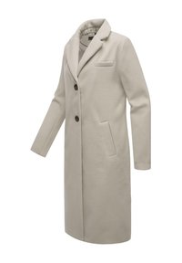 Beige wollen jas met lange mouwen, notch kraag, enkele knoopsluiting en zijzakken; heeft subtiele branding op de manchetten.