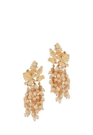 Boucles d'oreilles couleur or avec des dessus en forme de feuilles texturées et des grappes en cascade de petits perles beige rappelant des grappes de raisin.